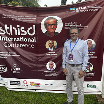 Akbar Saeed in front of a conference banner