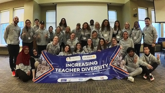 Increasing Teacher Diversity event participants posing as a group behind an event banner