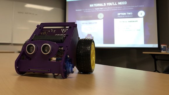 InkSmith's k8 micro:bit robot on a desk in front of a presentation