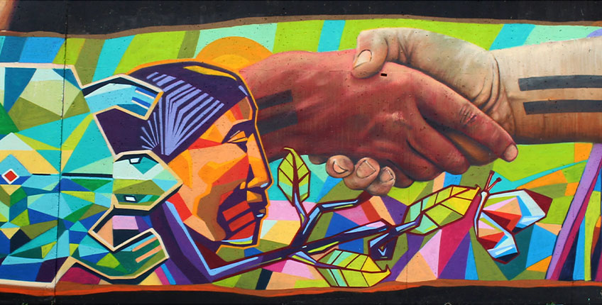 Indigenous mural on Laurier's Brantford Campus - section portrayed with turtle, profile of Indigenous person, shaking hands, branch, butterfly   Photo credit: #TAGProject