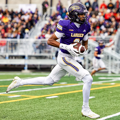 Golden Hawk team member running with football